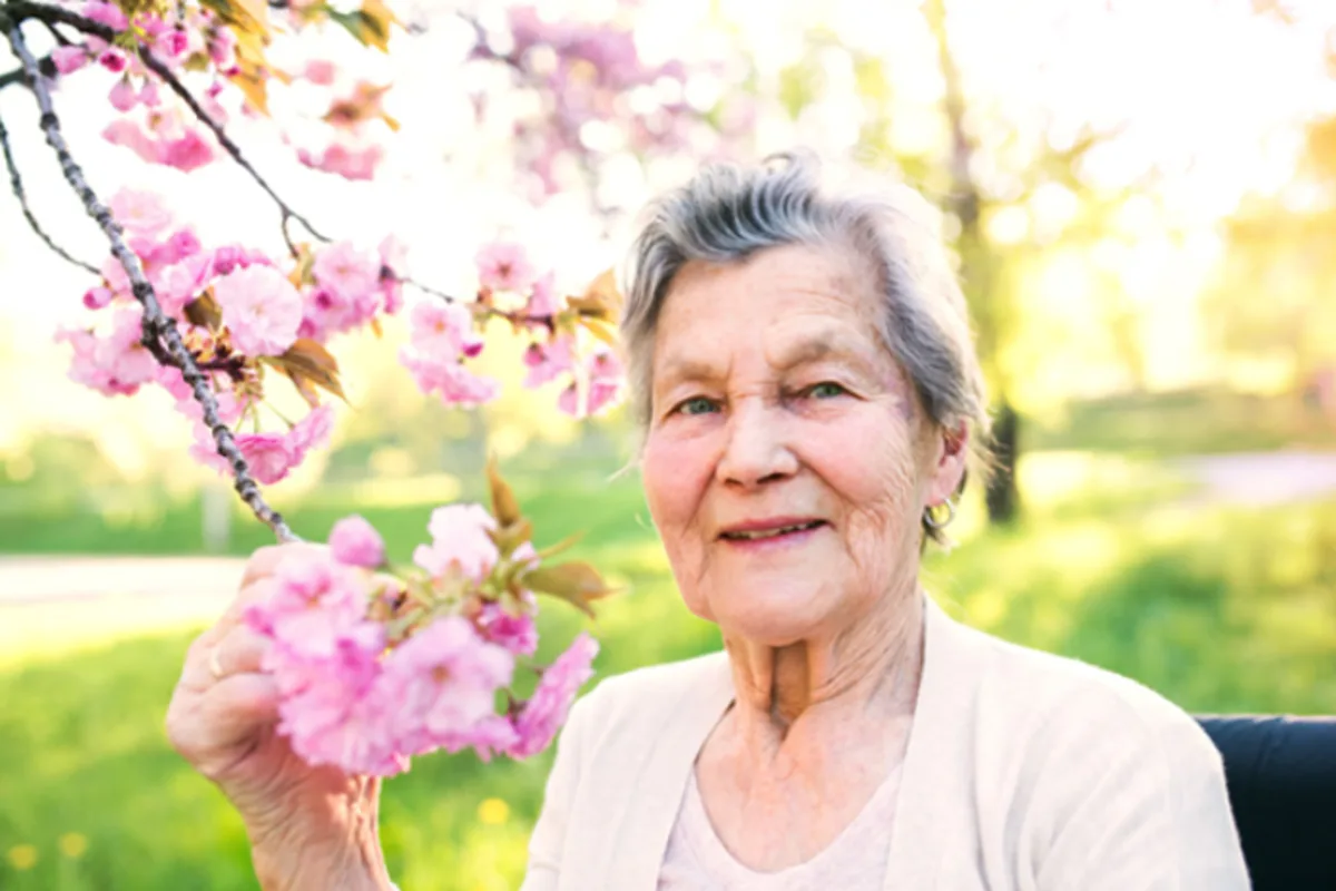 Oudere vrouw geniet rustig buiten — langer zelfstandig thuis met Memory Lane
